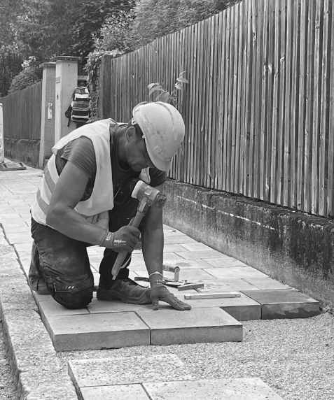 Worker laying paving stones